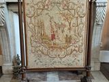 a fireplace screen in the middle of a room with a chandelier