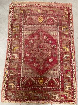 a red and yellow rug on a white floor