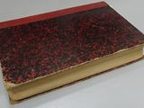 a red and black book sitting on a white table