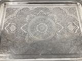 an ornate silver tray with a decorative design on it