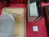 Plusieurs livres sont posés sur une table recouverte d'une nappe rouge.