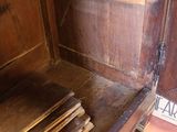a wooden cabinet that has a bunch of books inside of it