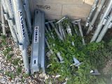 a pile of baseball bats sitting on the ground next to a brick wall
