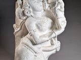 statue of a seated man holding a bird in his right hand