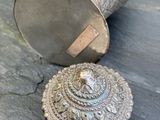 un objet en argent posé sur une table en pierre
