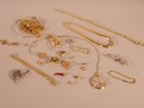 a lot of gold jewelry on a white table