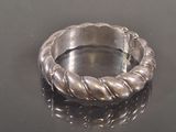 a silver bracelet with a chain on a black surface