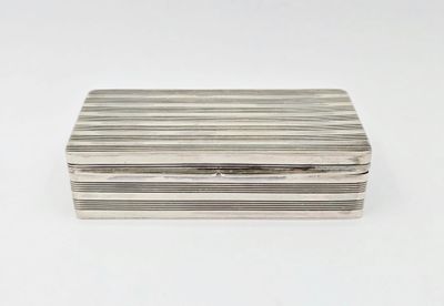 une boîte argentée posée sur une surface blanche, sur fond blanc