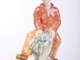 une figurine d'un homme assis sur un rocher