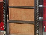 une bibliothèque noire et dorée surmontée d'une horloge