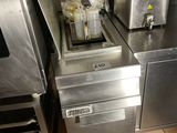 stainless steel counter top in a commercial kitchen with a fryer and sink