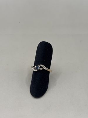un gros plan d'une bague posée sur un présentoir à bagues, sur une surface blanche