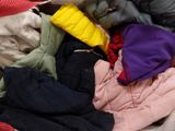 a pile of clothes that is sitting on a bed