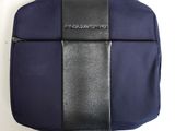 le dos d'un sac bleu et noir posé sur une surface blanche