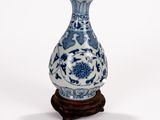 un vase bleu et blanc posé sur un support en bois