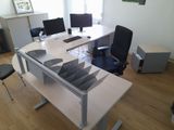 a desk with two computers and a chair in the room
