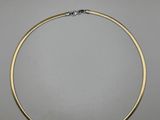 un collier fin en or orné d'un fermoir en diamant sur fond blanc