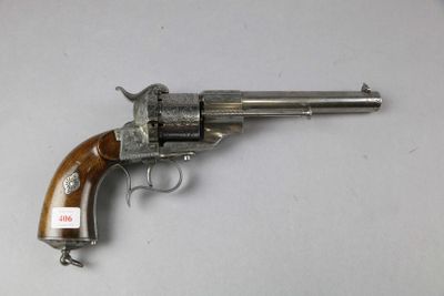 un vieux revolver avec une poignée en bois sur une surface blanche