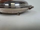a silver plate with a lid on a table