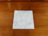 a white marble coaster sitting on top of a wooden table