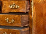 a wooden chest of drawers with a marble top