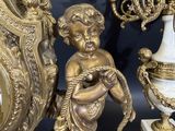 a statue of a boy holding a bird next to a clock
