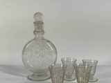 four glasses and a decanter sitting on a table
