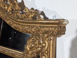 a gold mirror on the wall next to a white wall