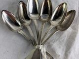 five spoons arranged in the shape of a flower on a table