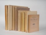 plusieurs vieux livres posés les uns sur les autres sur une surface blanche