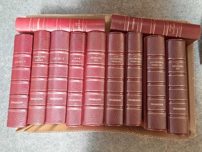 six livres rouges dans une boîte en carton posée sur une table