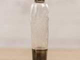 a small glass bottle sitting on top of a wooden table