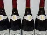 three bottles of red wine are lined up on a table