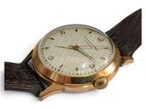 a close up of a watch on a white surface