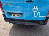 a blue van that is parked on the side of the road