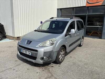 the small silver van is parked in front of a building