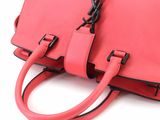 a close up of a pink handbag on a white background