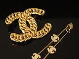 a close up of a gold chain bracelet and a pair of earrings