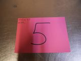 a close up of a pink note with a number 5 on it