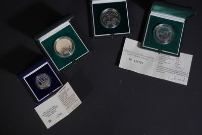 trois pièces d'argent sont posées sur une table noire