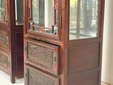 two tall wooden cabinets with glass doors on each of them