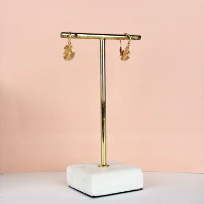 un gros plan sur une paire de boucles d'oreilles posées sur un présentoir sur une table