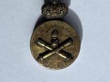 an image of a badge with a cross and a crown on it