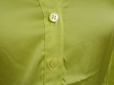 a close up of a green shirt with buttons on it