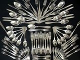 a lot of spoons and forks arranged in the shape of a sunburst
