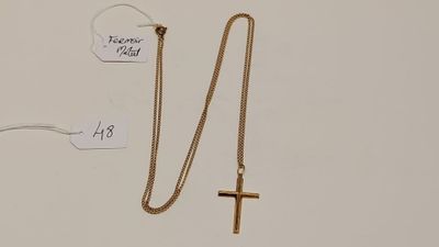 un gros plan d'un collier orné d'une croix et d'une étiquette