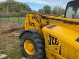 a yellow construction vehicle that is parked in the grass