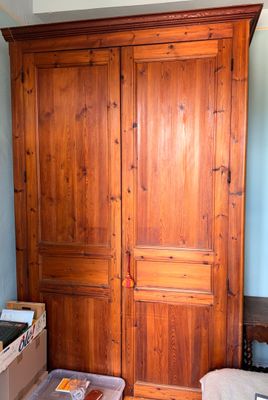 une photo d'une chambre à coucher avec une armoire en bois et un lit