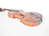 an old violin sitting on top of a white table next to a white wall
