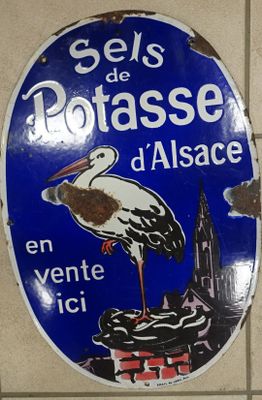 un panneau bleu surmonté d'une cigogne blanche